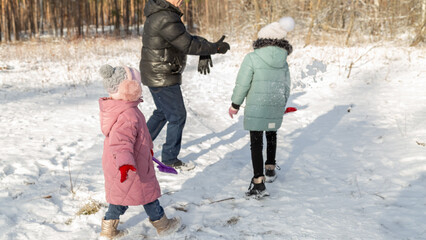 Little girls with her grandfather having fun on snowy winter day