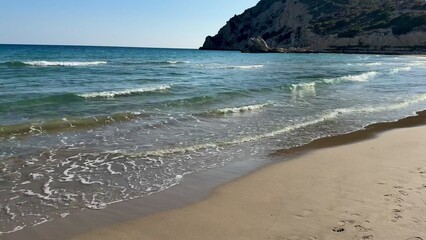 The Serene Beach Waves Dance Gently on a Bright and Sunny Day Beneath a Clear Blue Sky