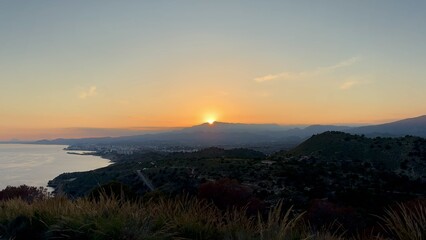 A stunning sunrise casts golden light over the tranquil coastline, creating a breathtaking view