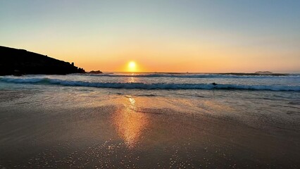 Obraz premium A Serene and Beautiful Sunset Over the Tranquil and Calming Waves of the Beach at Dusk