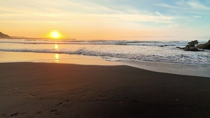 A Serene Beach Sunset Over Absolutely Calm Waves, Featuring Vibrant Colors and Beautiful Scenery