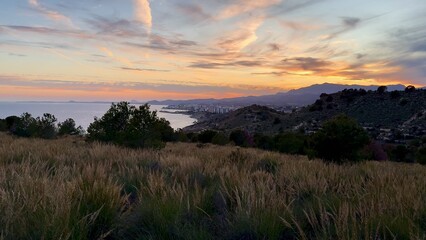 Experience the stunning coastal view at sunset, complemented by picturesque rolling hills nearby