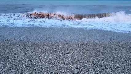 The calming waves gently lap against the shoreline during the beautiful twilight hours