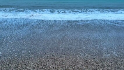 The soothing waves on a tranquil beach at dusk create a truly peaceful atmosphere