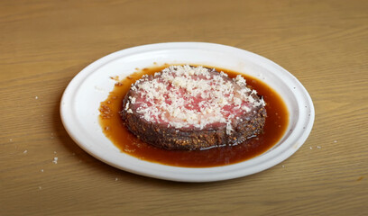 Wagyu prime rib steak with grated horseradish served in rich jus on a white plate
