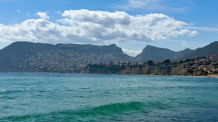 Experience serene coastal views with majestic mountains and clear waters, an idyllic escape