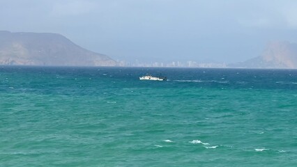 Fototapeta premium A Beautiful Ocean Scene Featuring a Picturesque Boat Sailing in Vibrant, Clear Waters