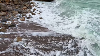 Fototapeta premium Breathtaking Waves Powerfully Crashing on a Beautiful Rocky Shoreline at Dusk during Sunset