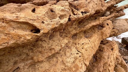 A Beautifully Textured Rock Formation Located by the Scenic Shoreline of the Ocean