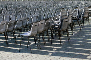 Empty plastic chairs arranged in rows at St. Peter's Square in Vatican City, early morning. Calm...