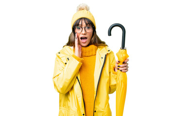 Young caucasian woman with rainproof coat and umbrella over isolated chroma key background with...