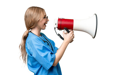 Naklejka premium Young nurse English woman over isolated background shouting through a megaphone