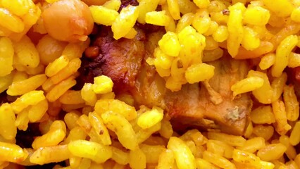 Enjoy the aromatic yellow rice dish with meat and chickpeas for a delightful meal