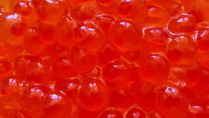 Vivid red fish roe on a pristine white plate showcases a gourmet delicacy that delights