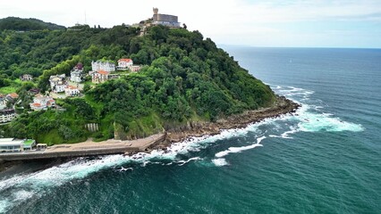 A stunning drone view of a coastal hill with lush greenery and the vast ocean, ideal for adventure
