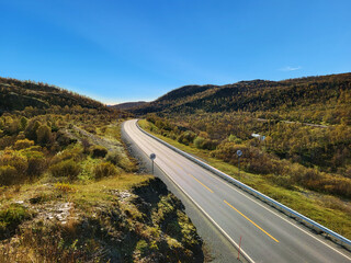 Road in national park in Norway, summer roadtrip background. Empty asphalt road through the wild Scandinavian landscape. Remote highway in Norway for travel, road trip and freedom concept.