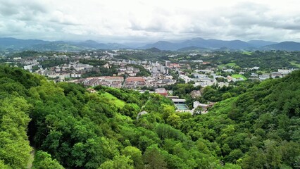 Obraz premium Breathtaking Scenic Overlook of a Vibrant City Nestled Among Lush Green Mountains