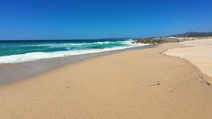 A Beautiful Tranquil Beach with Gentle Waves and a Clear Bright Sky, Perfect for Relaxation