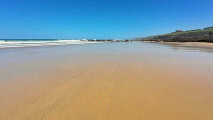 A Serene Beach Landscape Featuring Stunning Golden Sand and Clear Bright Blue Skies