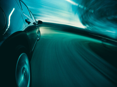 Close-up side view of a Car driving at speed on curved road at night, Illinois, USA