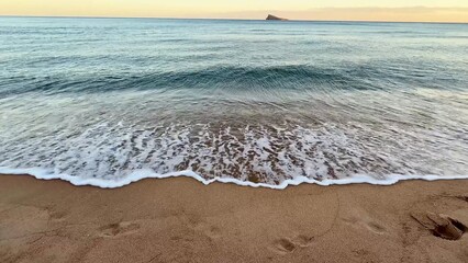 Experience the serene and beautiful beach view with gentle waves rolling in at sunset