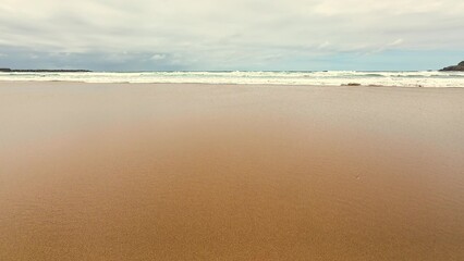 A Serene Coastal View Where Waves Gracefully Meet Beautiful Golden Sand Along the Shoreline