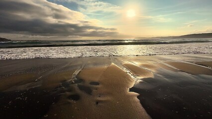 A Beautiful Serene Beach Sunset with Gentle Waves Crashing on the Golden Sand Shore