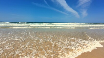 The soothing sound of tranquil beach waves creates a perfect atmosphere on a sunny day