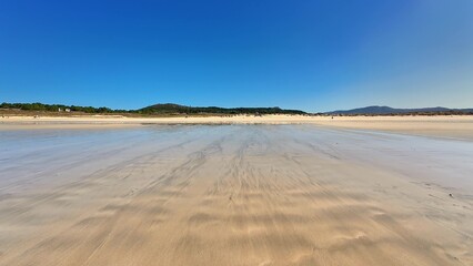 Enjoy the Serene Beach Landscape Featuring a Clear Blue Sky and Beautiful Reflections