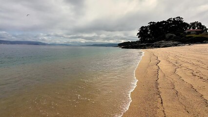 A Serene Beach View showcasing Calm Waters beneath an Overcast Sky, inviting relaxation and peace