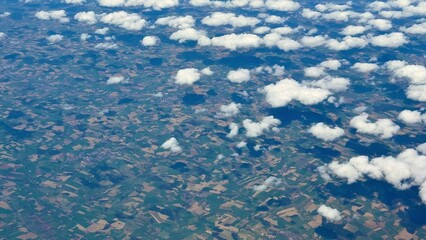 An Aerial View of Lush Green Fields Accompanied by Fluffy White Clouds in the Sky