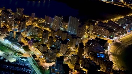 Obraz premium Experience the Stunning Aerial Night View of a Beautiful Coastal City, Filled with Lights and Life