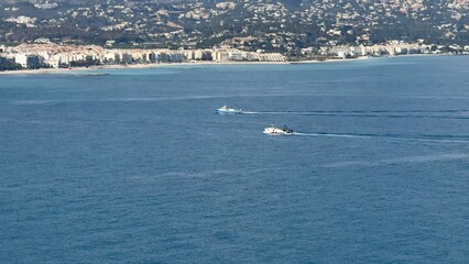 Obraz premium The stunning coastal view shows boats floating in the vibrant, clear ocean waters