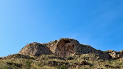 A Breathtaking Rock Formation Standing Tall Against a Beautiful Clear Blue Sky Above
