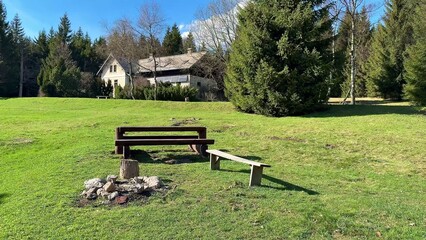 Obraz premium A tranquil outdoor setting with benches and a cozy campfire ring for relaxing in nature