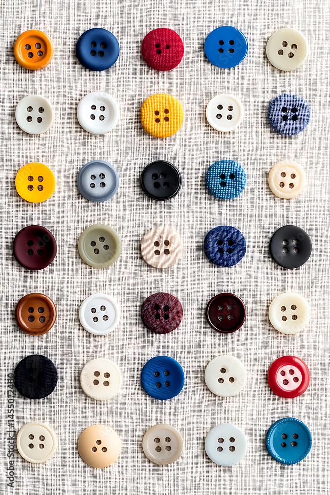 Poster collection of colorful sewing buttons arranged on a textured background, showcasing a variety of sha