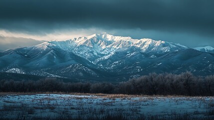 Majestic snow-capped mountain range under stormy sky.