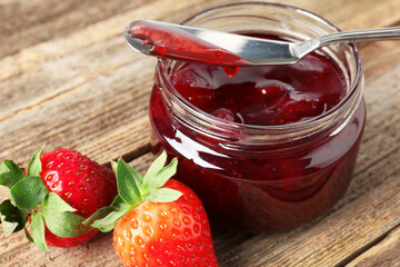 Delicious strawberry sauce and fresh berries on wooden table, closeup