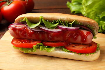 Tasty hot dog with tomatoes, onion, lettuce and ketchup on table, closeup