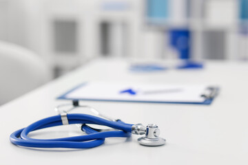 Stethoscope and paperwork on desk in doctor's office. Space for text