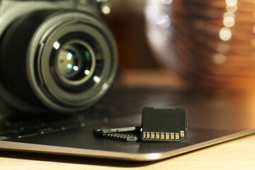 SD memory cards, laptop and photo camera on table, closeup