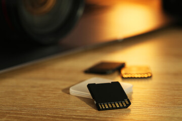 SD memory cards and holder on wooden table, closeup