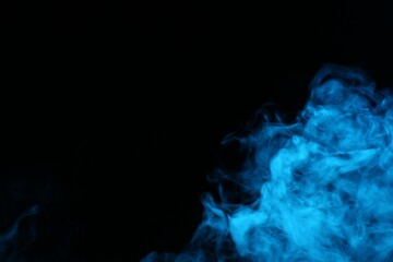 Beautiful smoke in blue light on dark background, space for text