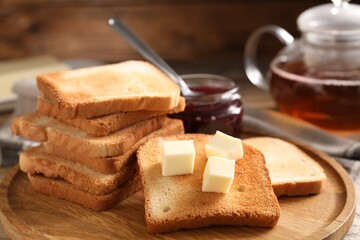 Slices of tasty toasted bread with butter on table, closeup