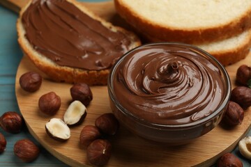 Chocolate hazelnut spread in bowl, nuts and toasts on table, closeup