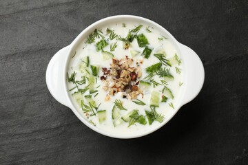 Fresh tasty cucumber soup on black table, top view
