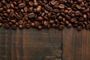 Aromatic coffee beans on wooden table, top view. Space for text