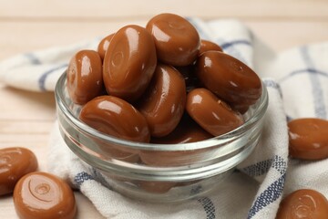 Many tasty caramel candies on white wooden table, closeup