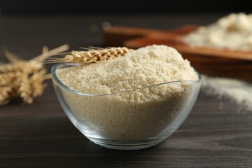 Flour and spike in bowl on dark wooden table, closeup