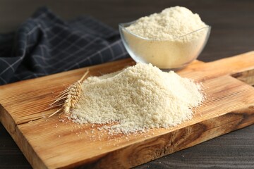 Pile of flour and spike on dark wooden table, closeup